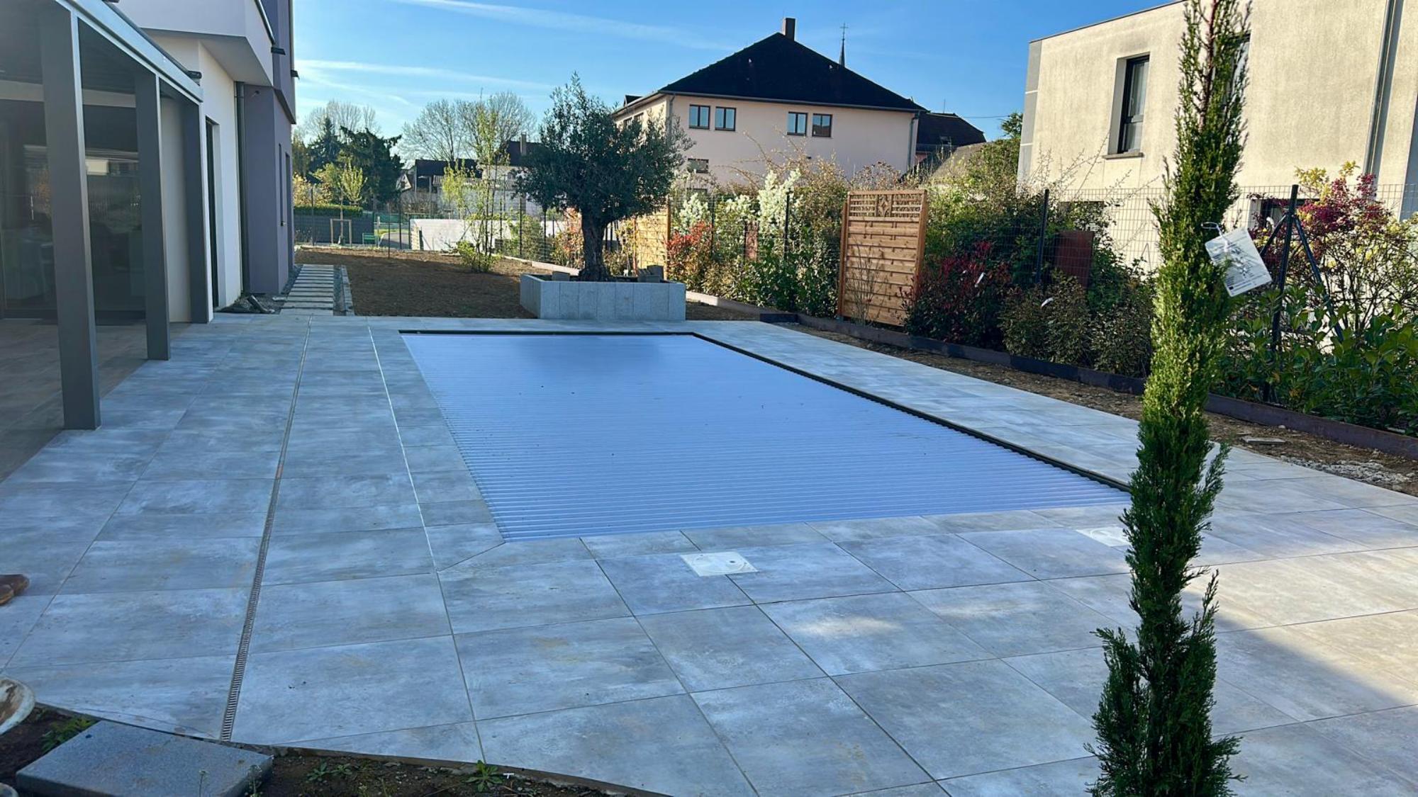 Construction d’une piscine 4×8,60 &agrave; Village Neuf, carrelage Bali, et am&eacute;nagement ext&eacute;rieur terrasse dalle, am&eacute;nagements paysagers espace vert, am&eacute;nagement cours avec enrob&eacute; et pav&eacute;s. Kingersheim